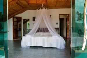 a bedroom with a bed with a mosquito net at Oceanside Villa in Puerto Galera