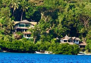 a house on the shore of a body of water at Oceanside Villa in Puerto Galera