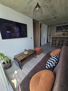 a living room with a couch and a flat screen tv at Loft type apartment premium style with pool in Barranquilla