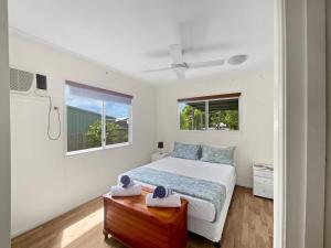 a white bedroom with a bed and two windows at Gigi's Getaway in Horseshoe Bay