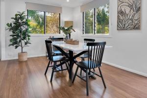 a dining room with a table and chairs at Birdwing Retreat in Picnic Bay