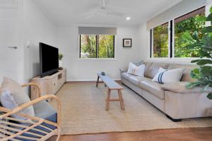 a living room with a couch and a tv at Birdwing Retreat in Picnic Bay