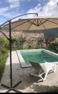a chair and an umbrella next to a swimming pool at Villa Maria Dilijan in Dilijan