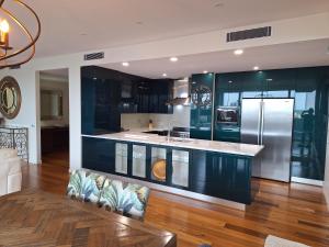 a kitchen with black cabinets and a stainless steel refrigerator at Honeysuckle Executive Apartments in Newcastle