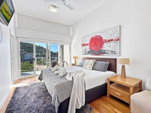 a bedroom with a large bed and a window at Beachside 17 in Nelly Bay +13 photos