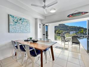 a dining room with a wooden table and chairs at Beachside 17 in Nelly Bay