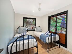 two beds in a room with two windows at Alma Rocks in Arcadia
