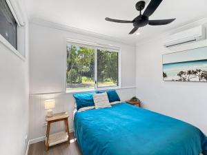a bedroom with a blue bed and a window at Tropic 21 in Picnic Bay +15 photos
