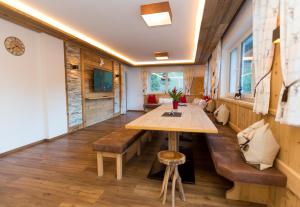 ein Esszimmer mit einem Holztisch und Bänken in der Unterkunft Ferienhaus Alpenherz in Finkenberg