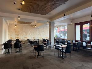 a restaurant with tables and chairs in a room at Queens Head Hotel in West Hobart
