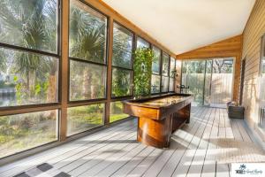 a pool table in a room with windows at Waterfront Zen-Dock, Paddleboards, Jacuzzi & Games in St. Augustine
