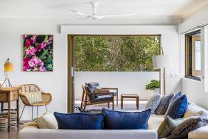 a living room with a couch with blue pillows at Salt Luxury Location in Sunshine Beach