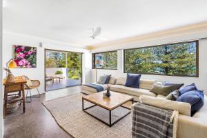 a living room with a couch and a table at Salt Luxury Location in Sunshine Beach