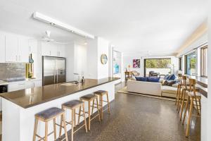 a kitchen and living room with a bar and a couch at Salt Luxury Location in Sunshine Beach