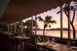 a restaurant with tables and chairs and a view of the ocean at Courtyard by Marriott Okinawa Resort in Nago