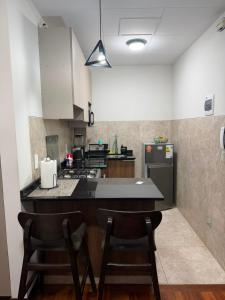 a kitchen with two chairs and a counter top at Monoambiente en sopocachi in La Paz