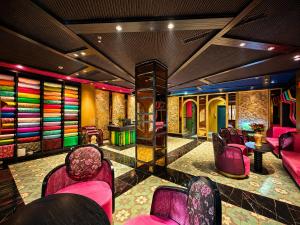 a lobby with pink chairs and colorful walls at Loom Hotel Hanoi in Hanoi