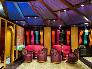 a room with chairs and tables and colorful walls at Loom Hotel Hanoi in Hanoi