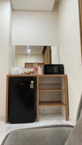 a kitchen with a black refrigerator and a microwave at The W Residence in Jakarta +24 photos