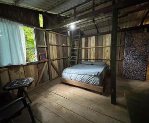 a room with a bed in a wooden cabin at Donde Sergio - Acantilados in Buenaventura
