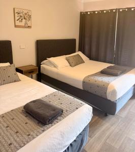 two beds sitting in a room withskirts at Corrigin Windmill Motel in Corrigin +2 photos