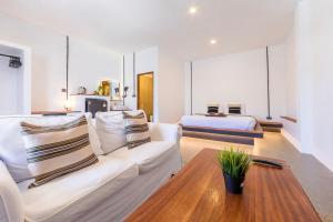 a living room with a couch and a bed at Infinity Guesthouse in Ko Tao