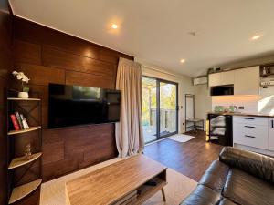 a living room with a couch and a flat screen tv at Modern Mountain Retreat in Ohakune