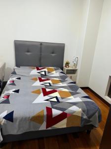 a bed with a colorful quilt on it in a room at Monoambiente en sopocachi in La Paz
