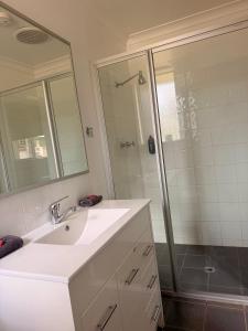 a white bathroom with a sink and a shower at Corrigin Windmill Motel in Corrigin