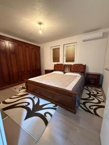 a bedroom with a large bed and a rug at Villa Calypso Sarajevo in Sarajevo