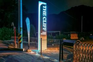 a neon sign for a building with a gate at The Cliff Caravan Camping in Pocheon