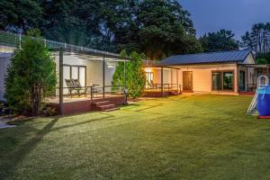 a house with a yard with a swing at The Cliff Caravan Camping in Pocheon +11 photos