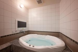 a large bath tub in a room with a tv at HOTEL Karin in Tokyo +36 photos
