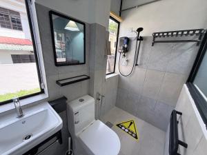 a small bathroom with a toilet and a sink at Dino House in Taiping +51 photos