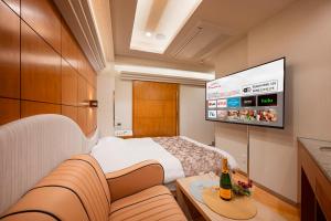 a hotel room with a bed and a flat screen tv at HOTEL Karin in Tokyo