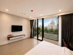 a bedroom with a large window with a view of a building at Coline Hotel & Aparment in Ninh Binh
