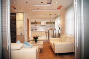 a living room with two white couches and a kitchen at Brivibas LUX in Riga