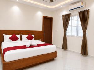 a bedroom with a large bed with red and white pillows at K V Comforts in Chikmagalūr