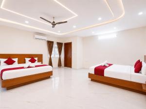 a bedroom with two beds and a ceiling at K V Comforts in Chikmagalūr