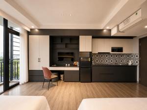 a kitchen with black and white cabinets and a table at Coline Hotel & Aparment in Ninh Binh