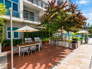 a patio with a table and chairs and umbrellas at Glendale Luxe Stays - Downtown in Glendale