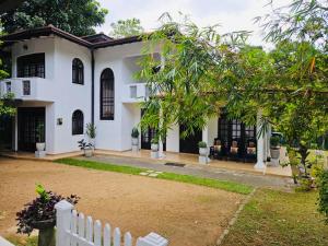 a white house with a fence in front of it at Deke Kanuwa in Kandy