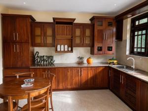 a kitchen with wooden cabinets and a wooden table at Deke Kanuwa in Kandy