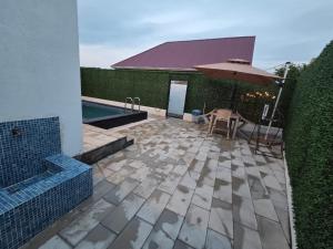 a patio with an umbrella next to a swimming pool at A-frame-WHITE HOUSE-II in Qusar