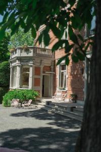 a building with chairs in front of it at Le Jardin des Roses Mons & Pairi Daiza proches in Dour