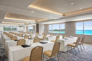 a conference room with white tables and chairs and the ocean at Courtyard by Marriott Okinawa Resort in Nago +83 photos