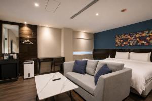 a hotel room with a bed and a couch at P&F Hotel in Taichung