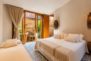 a bedroom with two beds and a patio at Las Dunas Beach house en Santa veronica cerca a la playa in Juan de Acosta