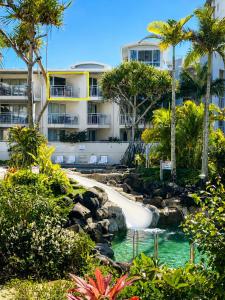 a resort with a water slide and palm trees at Top Floor , Ocean and Resort Pool Views at Alex Beach Resort for 2 !!! in Alexandra Headland