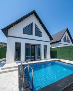 a house with a swimming pool in front of a house at A-frame-WHITE HOUSE-II in Qusar